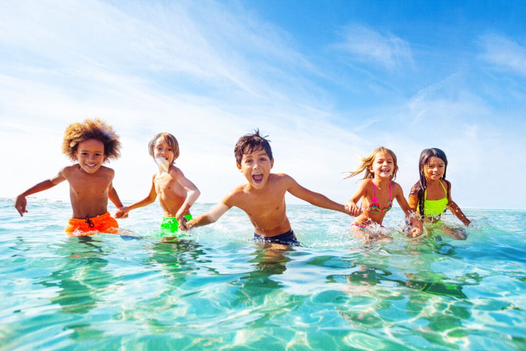 Kids laughing and playing in water at the seaside — Le Sentier des Pins à Ramatuelle