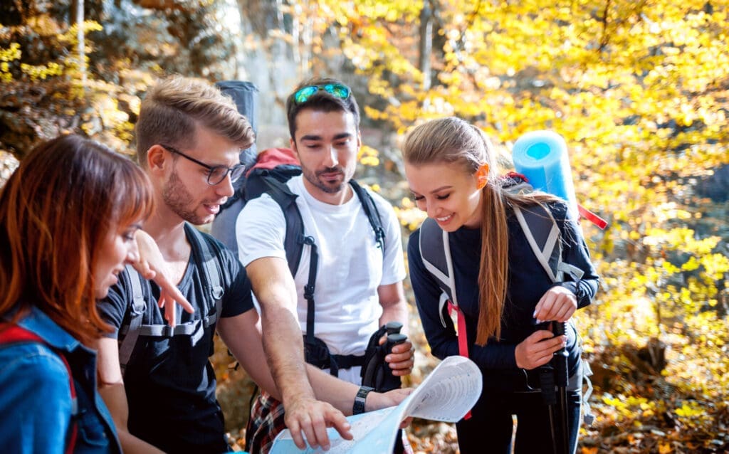Group of friends during trip navigating with map and planning… — Tailor-made