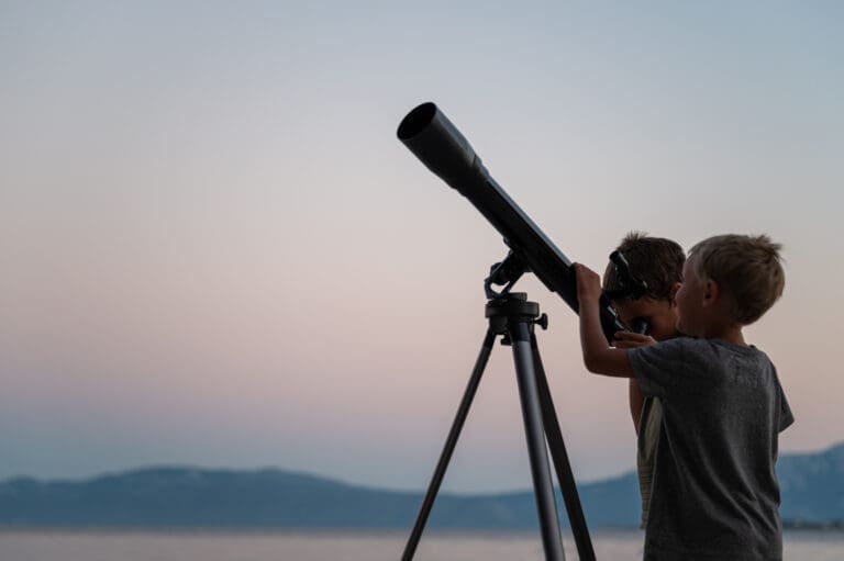 Two brothers looking at the stars using a telescope by the sea — Menu d'activité Les Coulmes & Les Rambins 2026