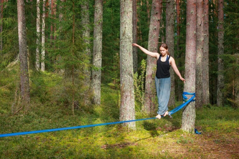 Girl performing balance activity in a lush forest setting — Menu d'activité Les Coulmes & Les Rambins 2026
