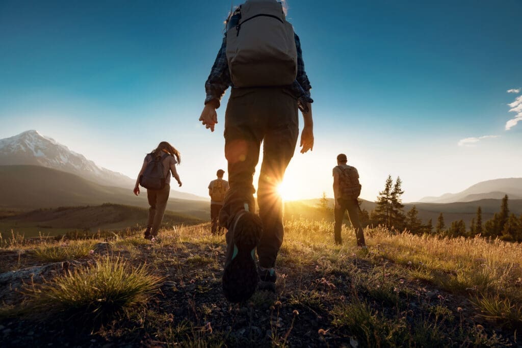 Group of sporty people walks in mountains at sunset with… — Hiking