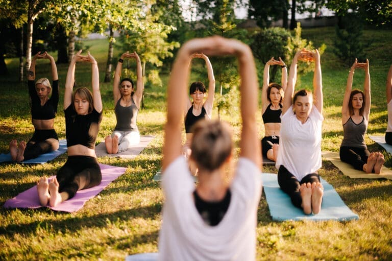 Group of women practising yoga with raised hands – Domaine de Sainte-Croix