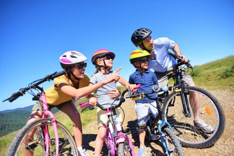 Family on a biking day, parents pointing at scenery — Randonnée VTT
