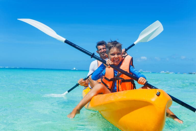 Father and son kayaking at tropical ocean