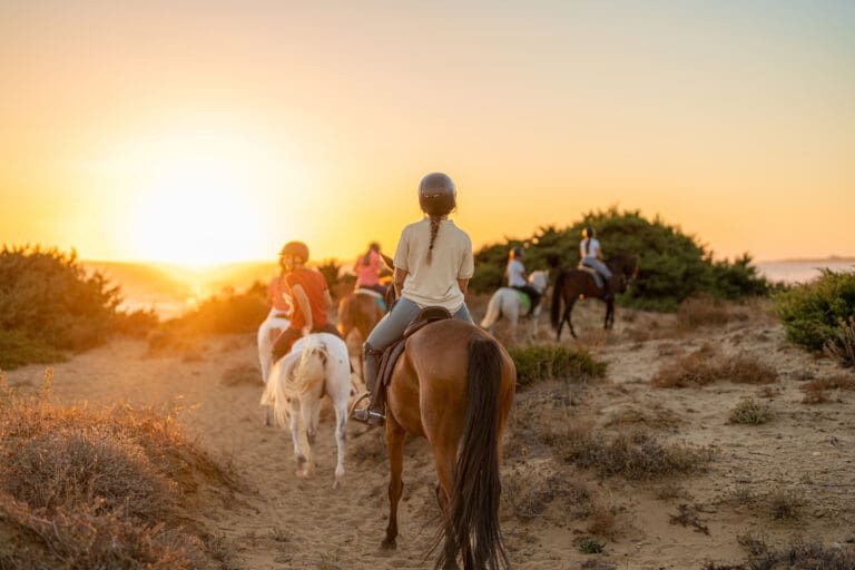 Group of young riders on horseback heading towards the beach — Sortie équestre