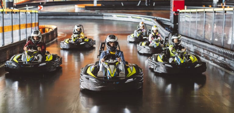Young man in a helmet leading a group of racers in a go kart… — Karting